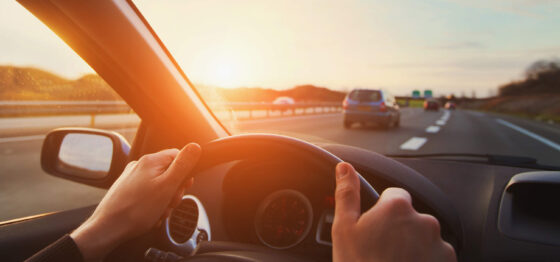 personne conduisant une voiture avec les deux mains sur le volant