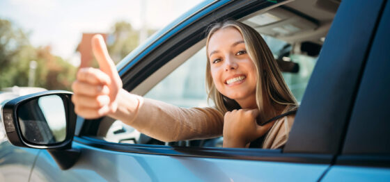 Jeune fille heureuse au volant d'une voiture