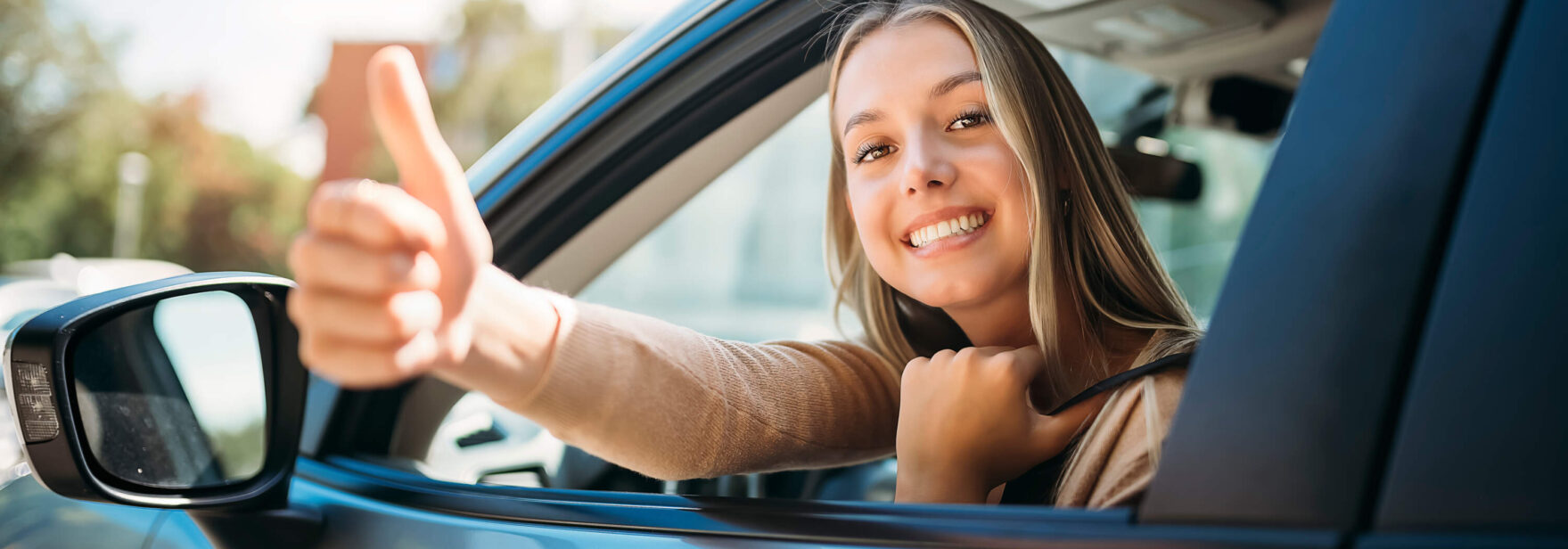 Jeune fille heureuse au volant d'une voiture